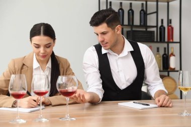 Sommelier 'ler kapalı bir masada farklı türde şarap tadıyorlar.