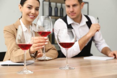 Sommelier 'ler kapalı bir masada farklı türde şarap tadıyorlar.