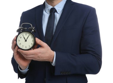 Beyaz arka planda alarm saati tutan bir iş adamı, yakın plan. Zaman yönetimi
