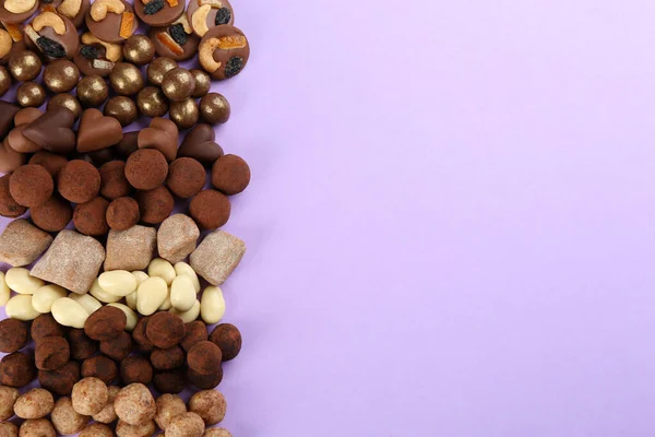 Verschiedene Leckere Schokoladenbonbons Auf Fliederfarbenem Hintergrund Flach Gelegt Raum Für — Stockfoto