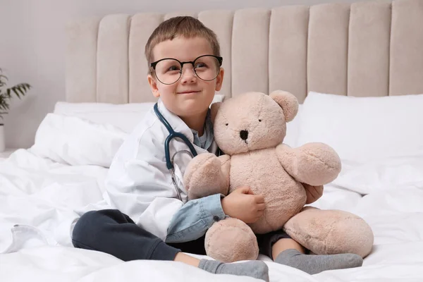 Söt Liten Pojke Barnläkarens Uniform Leker Med Stetoskop Och Leksaksbjörn — Stockfoto