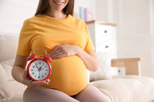 Young Pregnant Woman Holding Alarm Clock Her Belly Home Closeup — Stock Photo, Image