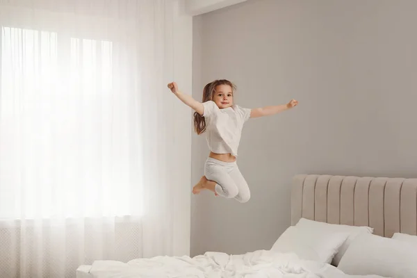 Симпатична Маленька Дівчинка Стрибає Ліжку Вдома — стокове фото