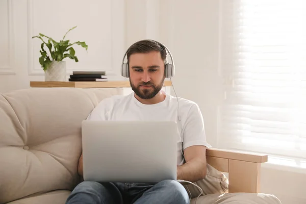 Hombre Con Portátil Auriculares Sentado Sofá Casa —  Fotos de Stock