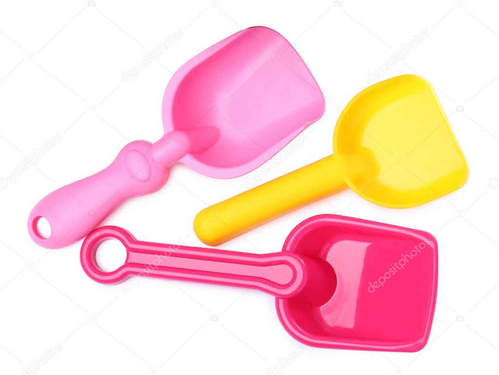 Bright plastic toy shovels on white background, top view