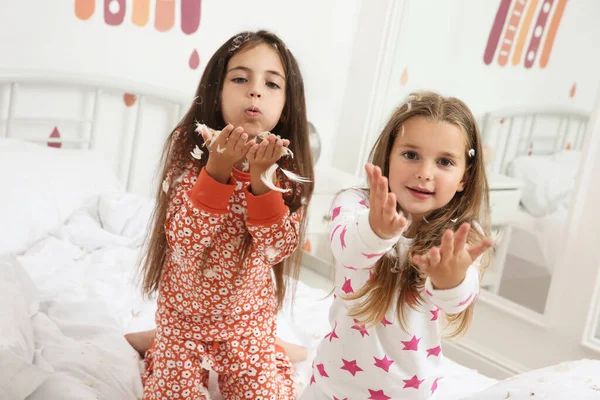 Χαριτωμένα Κοριτσάκια Πιτζάμες Που Παίζουν Φτερά Στο Κρεβάτι Στο Σπίτι — Φωτογραφία Αρχείου