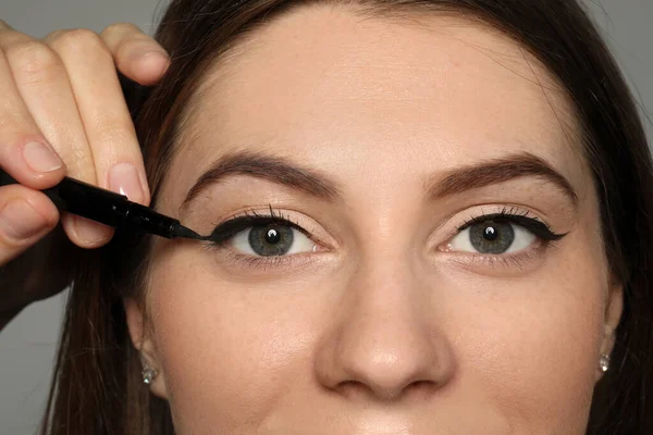 Artist Applying Black Eyeliner Woman Face Grey Background Closeup — Stock Photo, Image