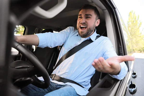 車の中で感情的な男 積極的な運転行動 — ストック写真