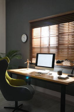 Modern bilgisayar ve rahat ofis sandalyesi olan şık bir oda.