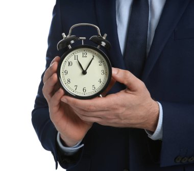 Beyaz arka planda alarm saati tutan bir iş adamı, yakın plan. Zaman yönetimi