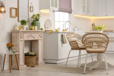 Kapalı alanda güzel bahar çiçekleri olan dekoratif bir şömine. İç tasarım