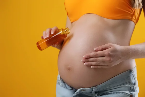 Young Pregnant Woman Sun Protection Oil Yellow Background Closeup Space — Fotografia de Stock