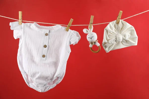 Baby Kleding Accessoires Opknoping Waslijn Tegen Rode Achtergrond — Stockfoto