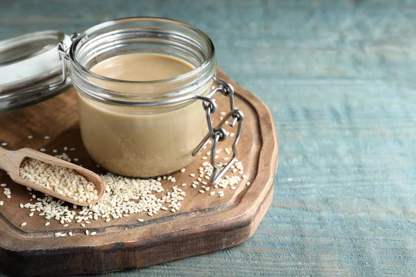 Jar Tasty Sesame Paste Seeds Scoop Light Blue Wooden Table — Stock Photo, Image