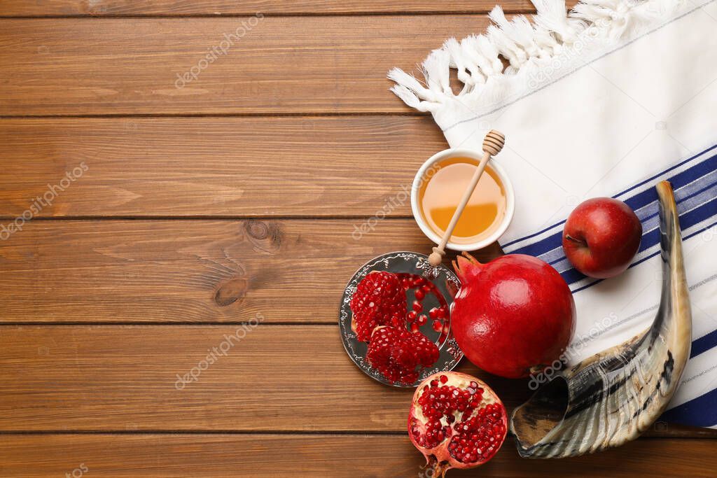 Flat lay composition with Rosh Hashanah holiday attributes on wooden table. Space for text