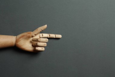 Gri arka planda tahta manken eli, üst manzara. Metin için boşluk