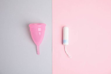 Renkli arka planda adet bardağı ve tampon, düz uzanma