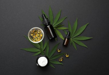Kenevir yaprakları, CBD yağı ve siyah zemin üzerindeki THC tentürü ile düz konum