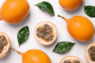 Lezzetli olgun granadillalar ve beyaz arka planda yapraklar, düz uzanmış