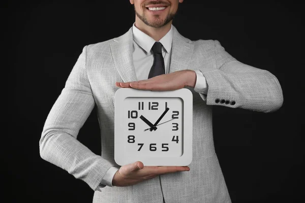 Feliz Hombre Negocios Sosteniendo Reloj Sobre Fondo Negro Primer Plano — Foto de Stock