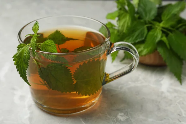 Стеклянная Чашка Ароматного Чая Крапивой Зелеными Листьями Светло Сером Столе — стоковое фото
