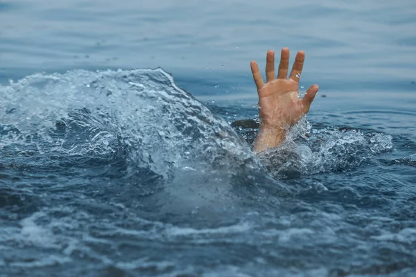 Drowning man reaching for help in sea, closeup