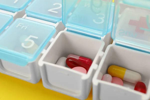Plastikowe Pudełko Różnymi Tabletkami Żółtym Tle Zbliżenie — Zdjęcie stockowe