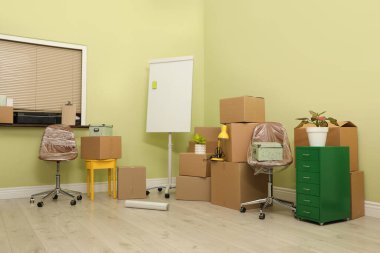 Yeni ofiste paketlenmiş eşyalarla dolu karton kutular. Taşınma günü