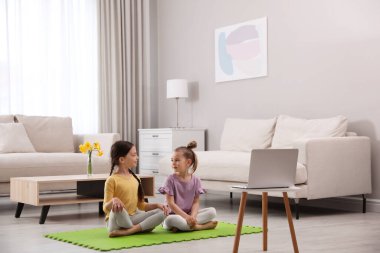 Cute little girls watching online dance class at home