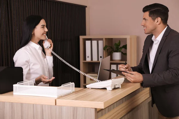 Receptionist Talking Phone While Working Client Countertop Office — Stock Photo, Image