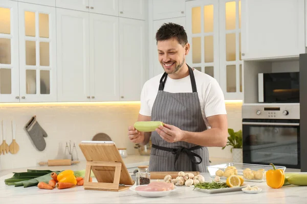 Happy Man Making Dinner While Watching Online Cooking Course Tablet — Stok fotoğraf