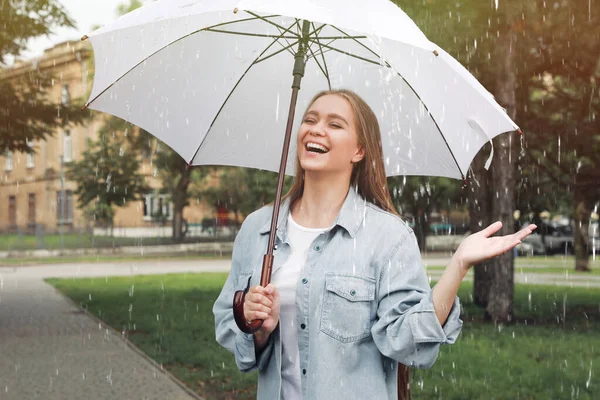 公園で雨の下を歩く傘を持つ若い女性 — ストック写真