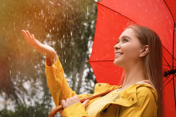 公園で雨の下を歩く傘を持つ若い女性 — ストック写真