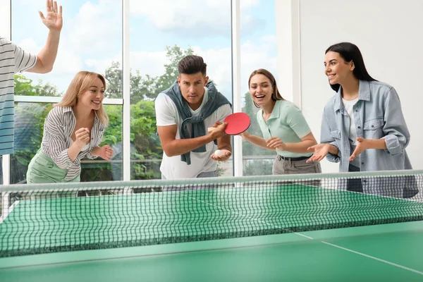 快乐的朋友们一起在屋里打乒乓球 — 图库照片