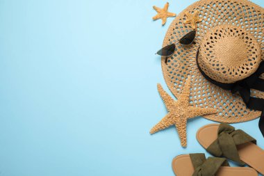 Açık mavi arkaplan üzerinde farklı plaj nesneleri ile düz kompozisyon, metin için boşluk