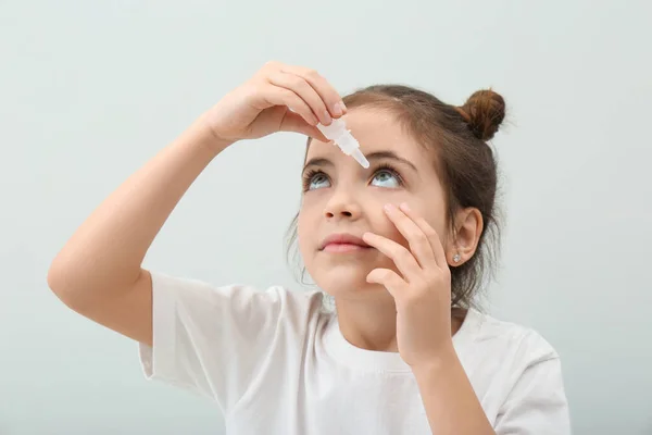 Bedårande Liten Flicka Med Ögondroppar Vit Bakgrund — Stockfoto