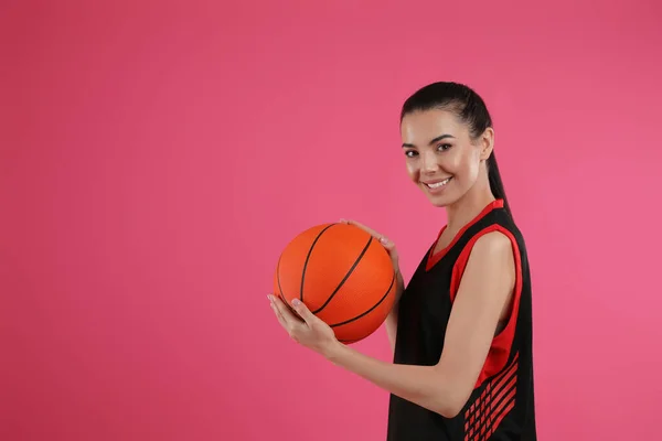 ピンクを背景にボールを持つバスケットボール選手 テキストのスペース — ストック写真