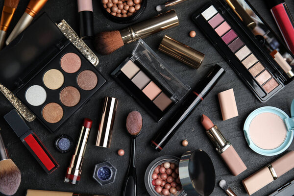 Плоская композиция с косметическими средствами на черном столе