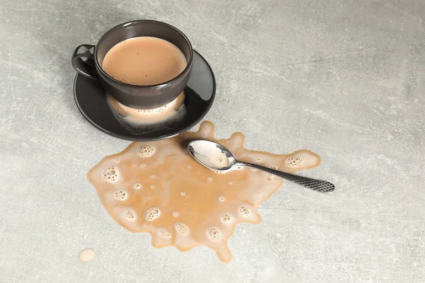 Tasse Untertasse Und Löffel Neben Verschüttetem Kaffee Auf Grauem Tisch — Stockfoto