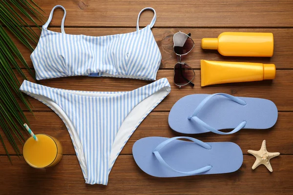 Tahta zemin üzerinde plaj nesneleri ile düz kompozisyon yatıyordu