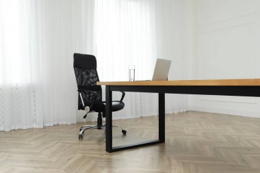 Büyük ahşap masası ve rahat koltuğu olan müdürün ofisi. İç tasarım