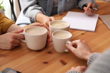 Kafede elinde kahve bardakları olan kadınlar, yakın plan.