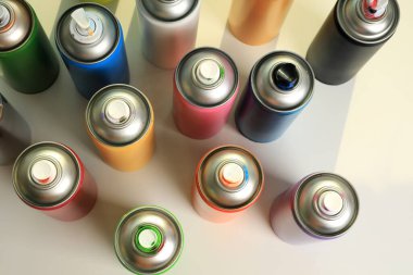 Farklı graffiti sprey boya kutuları beyaz masa, üst görünüm