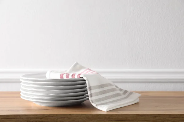 Mutfak Havlusu Temiz Bulaşık Takımı Beyaz Duvarın Yanındaki Ahşap Masada — Stok fotoğraf