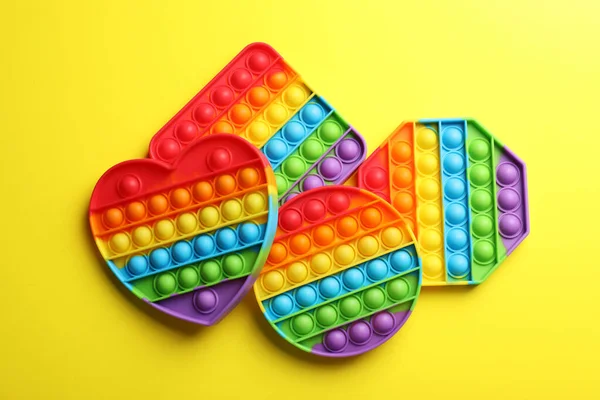 Many Different Rainbow Pop Fidget Toys Yellow Background Flat Lay — Foto de Stock