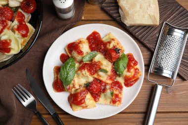 Ahşap masada servis edilen domates soslu lezzetli ravioli.