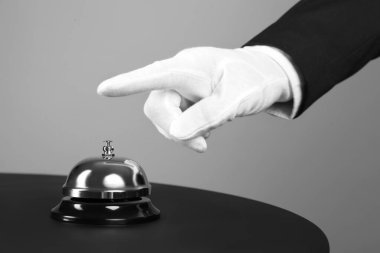 Uşak masadaki servis zilini çalıyor, yakın plan.