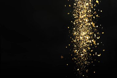 Siyah arka planda parlayan altın parıltı, yazı için boşluk. Bokeh etkisi