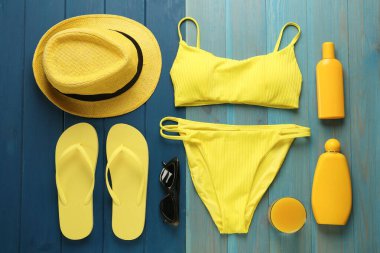 Mavi ahşap zemin üzerinde plaj nesneleri ile düz kompozisyon yatıyordu