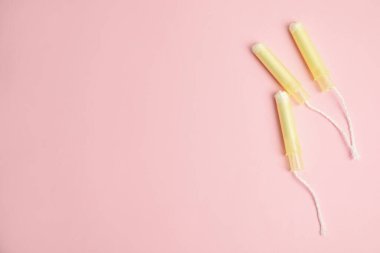 Açık pembe arka planda tamponlar, düz yatış. Metin için boşluk